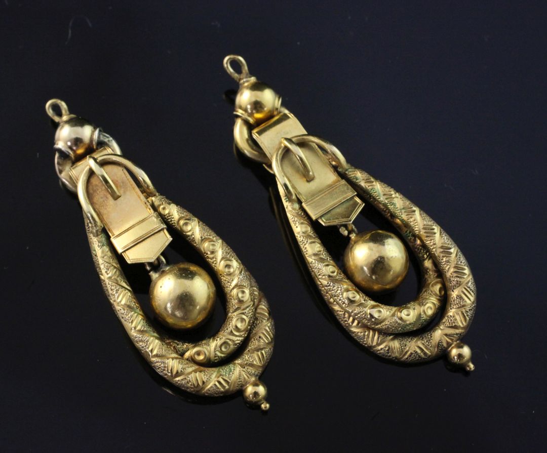 A pair of Victorian gold drop earrings, of engraved double loop and buckle design, (lacking ear