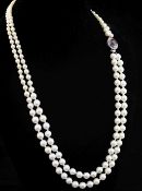 A double strand graduated cultured pearl necklace with a white metal, purple tourmaline and