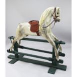 A large dapple grey rocking horse by Lines Brothers, on a green painted base, the front metal