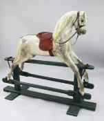 A large dapple grey rocking horse by Lines Brothers, on a green painted base, the front metal