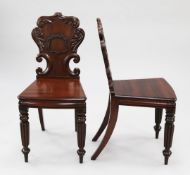 A pair of 19th century mahogany hall chairs, with acanthus leaf carved scrolling cartouche shaped