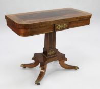 A Regency rosewood and brass inlaid fold over card table, with central tapering square section