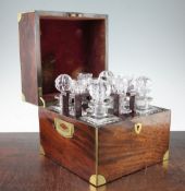 A George III mahogany and brass bound travelling decanter set, the hinged top opening to reveal four