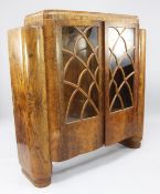 An Art Deco walnut display cabinet, with stepped top above a pair of glazed doors between projecting
