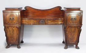 A Regency carved mahogany pedestal sideboard, the dipped centre fitted with a pair of projecting