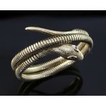 An early 1960's Victorian style 9ct gold coiled serpent bracelet, with engraved decoration and