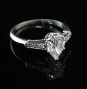 A platinum and single stone pear shaped diamond ring, with graduated diamond set shoulders, with E.
