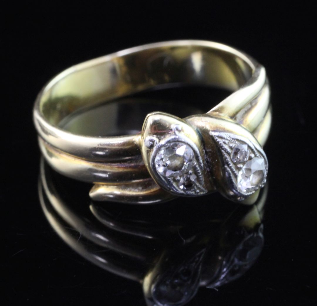 An early 20th century gold and diamond twin serpent ring, set with four old cut stones, size R.
