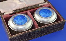 A cased pair of George V Arts & Crafts silver and blue enamel mounted clothes brushes by W.H.