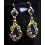 A pair of Victorian style gold and amethyst drop earrings, each with scrolling borders and set