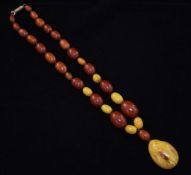 A single strand graduated amber bead drop necklace, with barrel shaped gilt metal clasp and ovoid