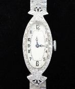 A lady's late 1920's 18ct white gold and diamond set cocktail watch, with oval Arabic dial, on a