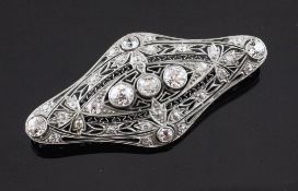 A 1920's platinum and gold, diamond set brooch, of shaped oval pierced openwork design, set with