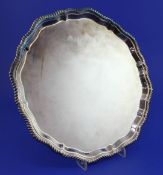 An early 1970's silver salver, of shaped circular form, with gadrooned border, on four scroll