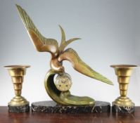 An Art Deco bronzed spelter clock garniture, modelled as a seagull flying over a wave, with drum