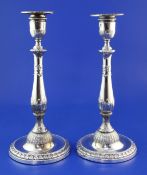 A pair of George III silver candlesticks by John Winter & Co, with baluster stem and decorated
