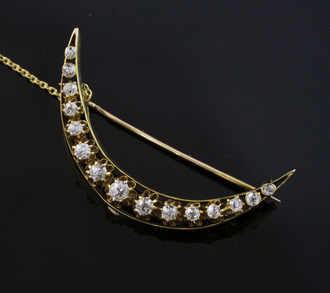 A Victorian style gold and diamond crescent brooch, set with fifteen graduated old cut diamonds,