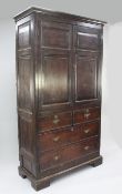 A George III oak press cupboard, the two doors with fielded panels above two short dummy drawers