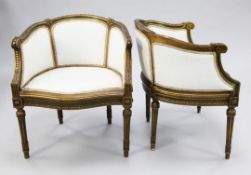 A pair of Louis XVI style green painted and parcel gilt tub shaped bergeres, with serpentine seats