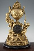 A 19th century French gold painted spelter mantel clock, modelled with putti around an urn, 20.5in.