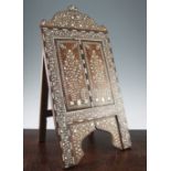 An Indian ebony and ivory inlaid easel mirror, profusely decorated with flowers, leaves and