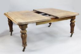 A large Victorian extending mahogany dining table, with four extra leaves, the top with rounded