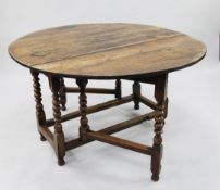 An early 18th century oak oval gate leg table, with bobbin turned supports united by stretchers,