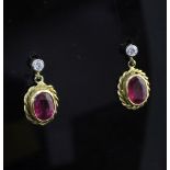 A pair of 18ct gold, ruby and diamond set drop earrings, of oval form, with spiral border.