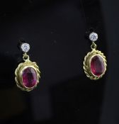 A pair of 18ct gold, ruby and diamond set drop earrings, of oval form, with spiral border.