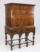 An 18th century walnut chest on later stand, fitted two short and three long graduated drawers,