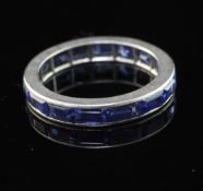 A white metal and sapphire full eternity ring, set with baguette cut stones, size K.