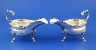 A pair of George III silver sauceboats by William Cattell, with fling scroll handles, beaded rims