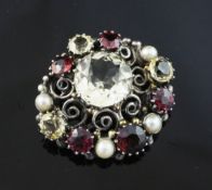 An early 20th century Arts & Crafts silver, citrine, garnet and split pearl set clip. of oval