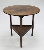A George III oak cricket table, with circular top above a triangular shaped undertier, united by