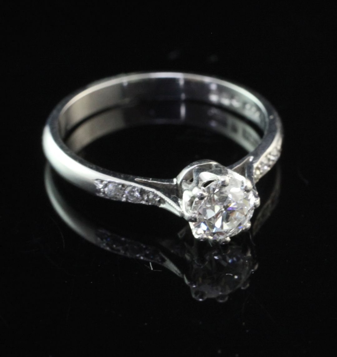 A platinum and single stone diamond ring, with diamond set shoulders, the central round cut stone
