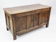 A late 17th century oak coffer, with triple panel fronts and applied turned pilasters, carved with