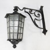 A large black painted hexagonal tapering lantern, with glass panels, and wrought iron hanging