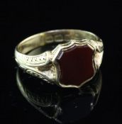 A late Victorian 18ct gold and carnelian set signet ring, with shield shaped stone and engraved