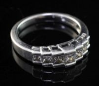 A modern platinum and graduated seven stone princess cut diamond half hoop ring, size L.