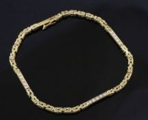 An 18ct gold and diamond fancy link bracelet, with three baton links, each set with five round cut