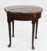 A mid 18th century mahogany triple fold over demi lune card table, on tapering supports and pad