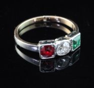 An early/mid 20th century gold and three stone emerald, diamond and red spinel ring, size H.