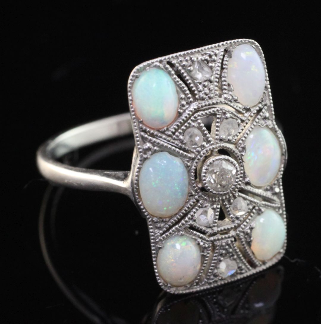 A 1920's platinum, white opal and rose cut diamond set tablet ring, with pierced millegrain setting,