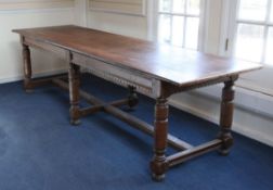 An oak refectory table, the plank top with cleated ends, on ring turned supports united by H frame