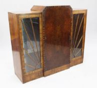 An Art Deco walnut and rosewood side cabinet, with stepped top above central panel door between
