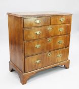 A George II walnut and featherbanded chest, of two short and three long graduated drawers with brass