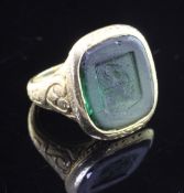 An antique style continental 18k gold and green tourmaline intaglio ring, with carved matrix