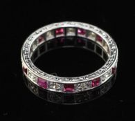 An 18ct white gold, ruby and diamond full eternity ring, set with eleven rubies with an estimated