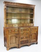 A George III oak Welsh dresser, the plate rack with pierced arched frieze, two fitted shelves and