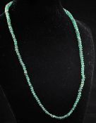 A single strand graduated emerald bead necklace, with 18ct gold fluted spherical clasp, 16.5in.